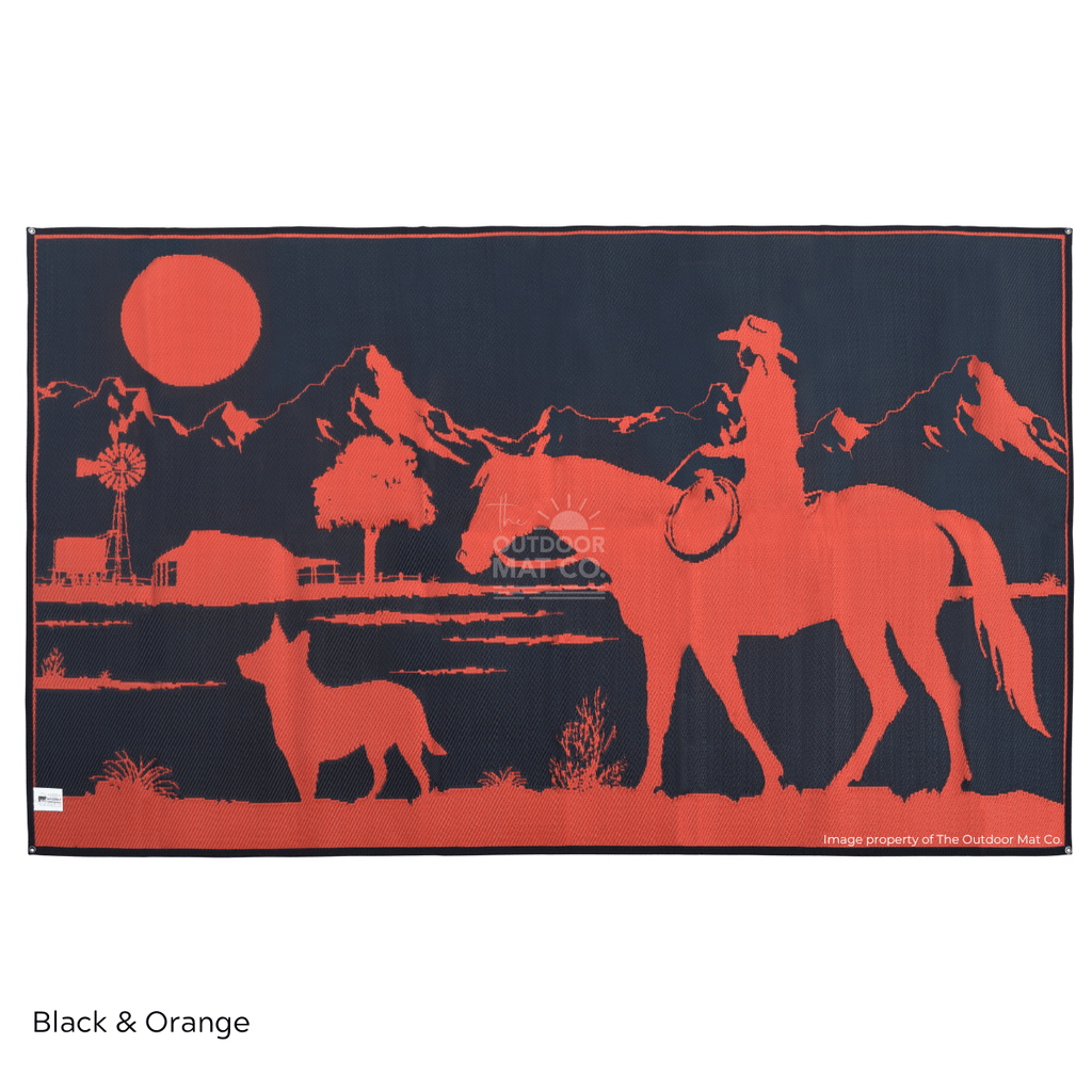 Black and orange recycled outdoor mat with cowboy, horse, dog, and mountain sunset scene for camping or beach use