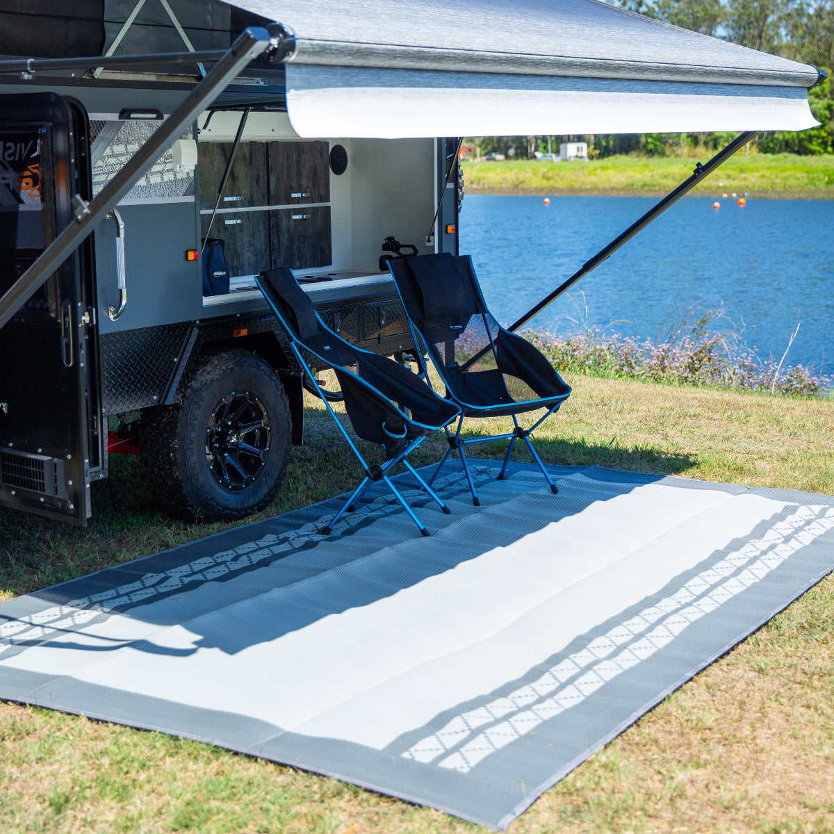 Recycled outdoor mat with tire track design under caravan awning, perfect for camping and beach days