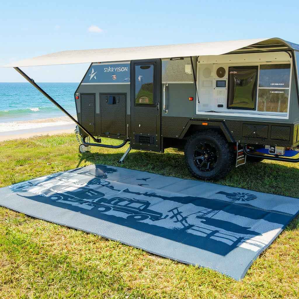 Recycled outdoor mat with truck design on grass near caravan at beach, perfect for camping and picnics