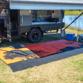 Vibrant red and orange recycled outdoor mat under caravan, perfect for camping and beach days