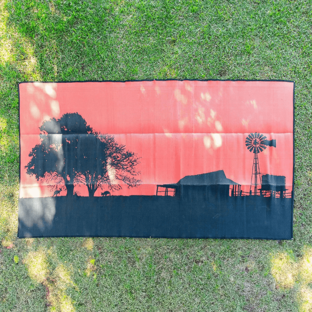 Recycled outdoor mat with rustic farm print, perfect for picnics, camping, or beach days on grass.