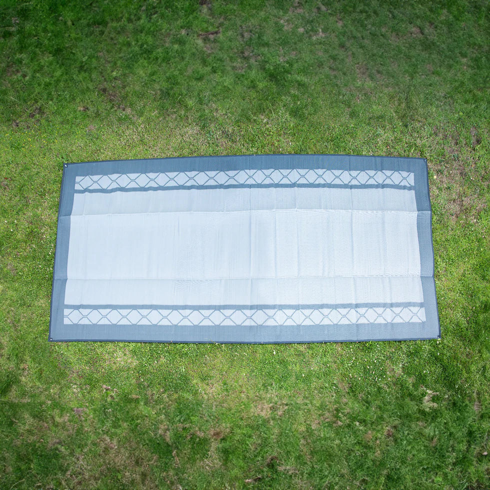 Recycled outdoor mat with geometric pattern on grass, ideal for picnics, camping, and beach days