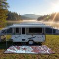 Eco-friendly recycled outdoor mat under caravan by lake, perfect for camping and picnics