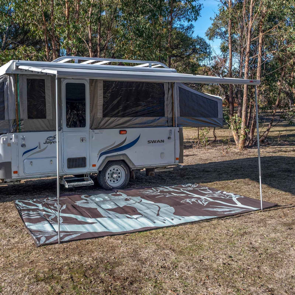 Recycled outdoor mat with eucalyptus design under caravan awning, perfect for camping and caravan trips.