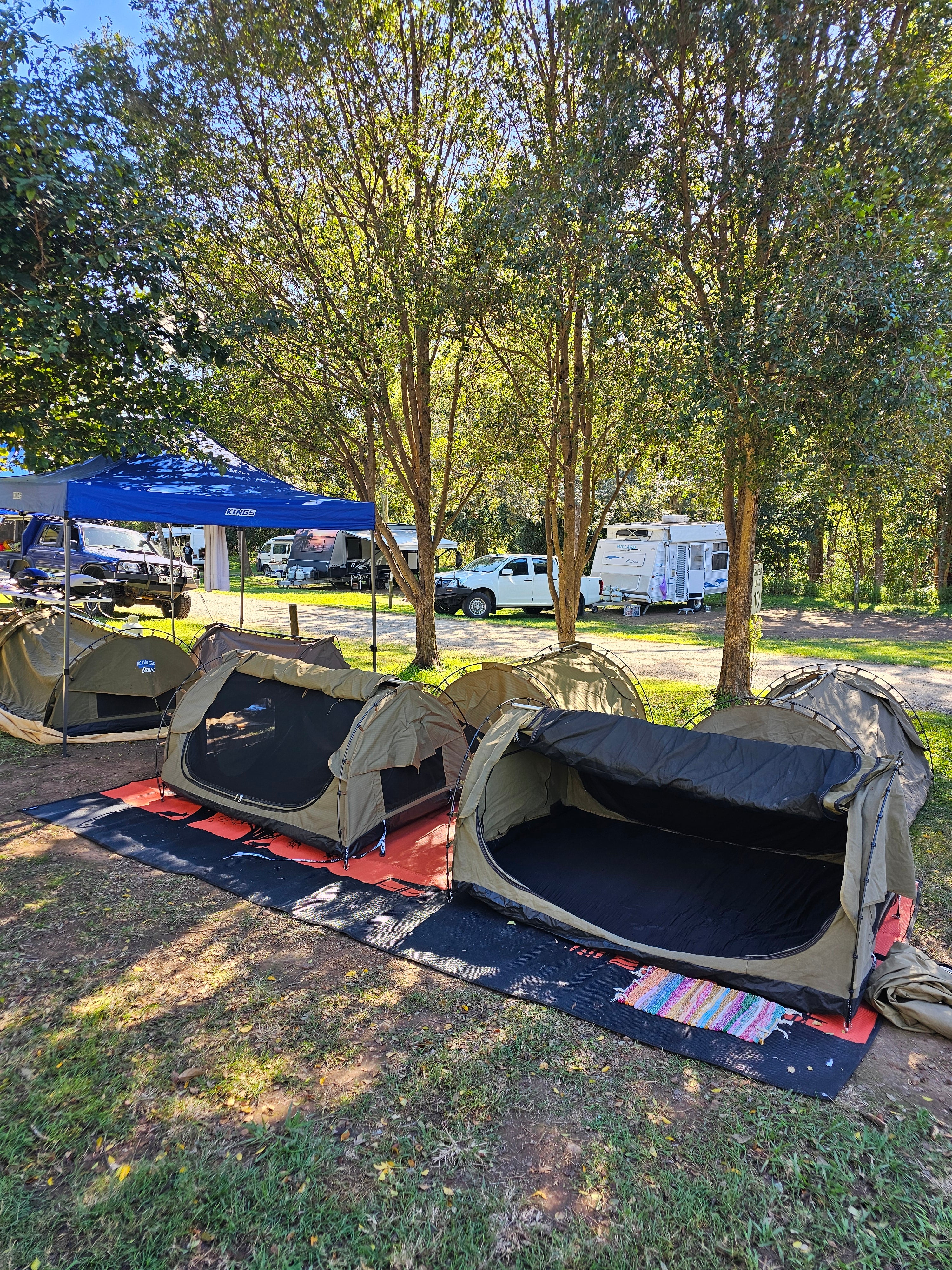 Eco-friendly outdoor mat under camping tents in a shaded park, perfect for camping, picnics, and caravan trips.