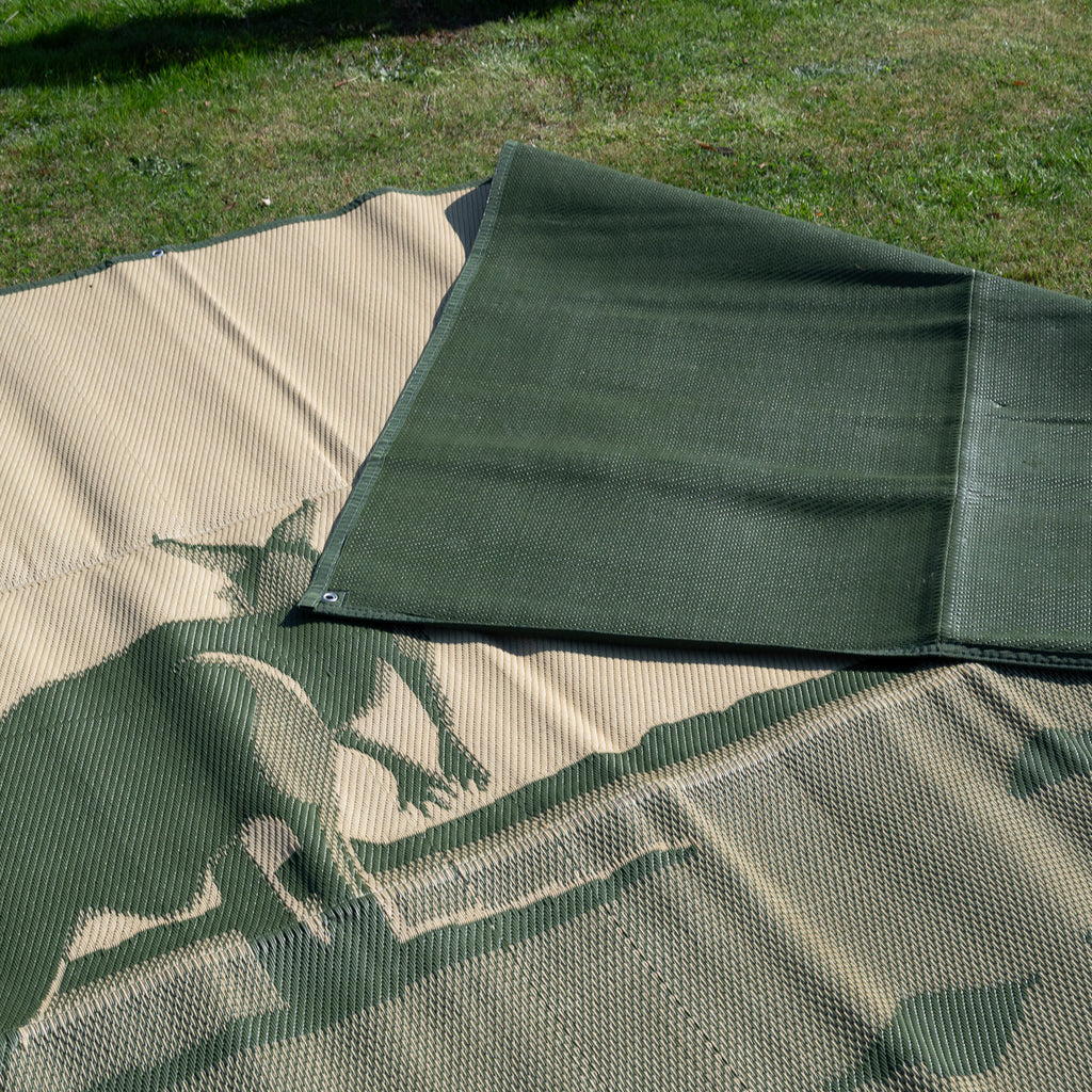 Camouflage outdoor mat on grass, ideal for camping, picnics, and beach days. Eco-friendly, recycled material.