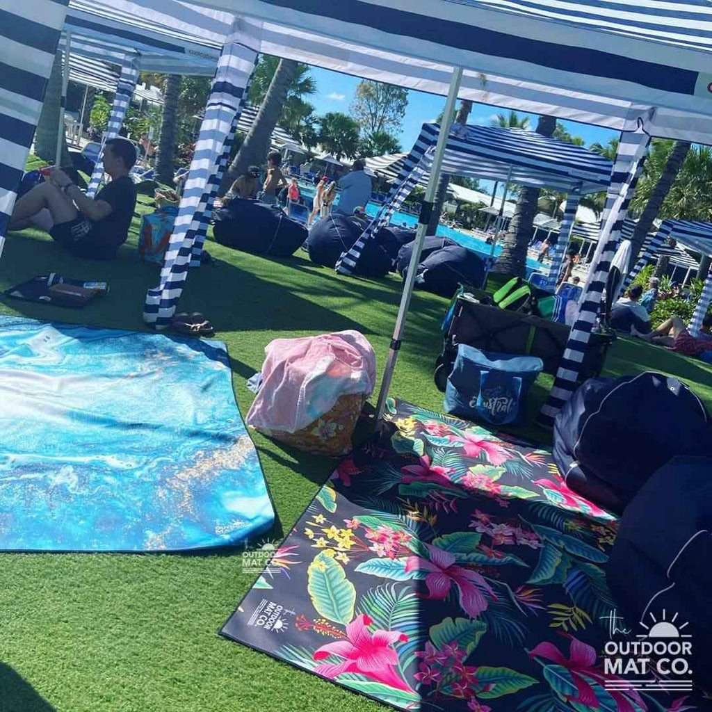 Colorful recycled outdoor mats under striped canopy at beach resort, perfect for picnics and camping