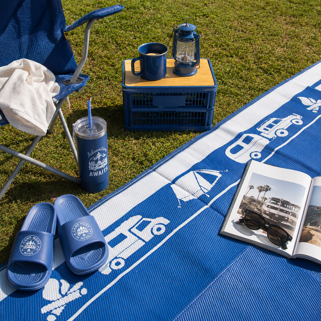 Blue recycled outdoor mat with camper van print, perfect for picnics, camping, or beach days with chair, lantern, and tumbler.