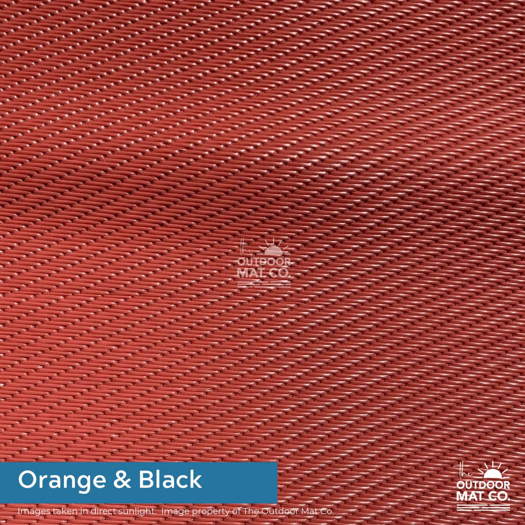 Orange & black recycled outdoor mat with woven texture, ideal for beach, camping, picnics, and caravans