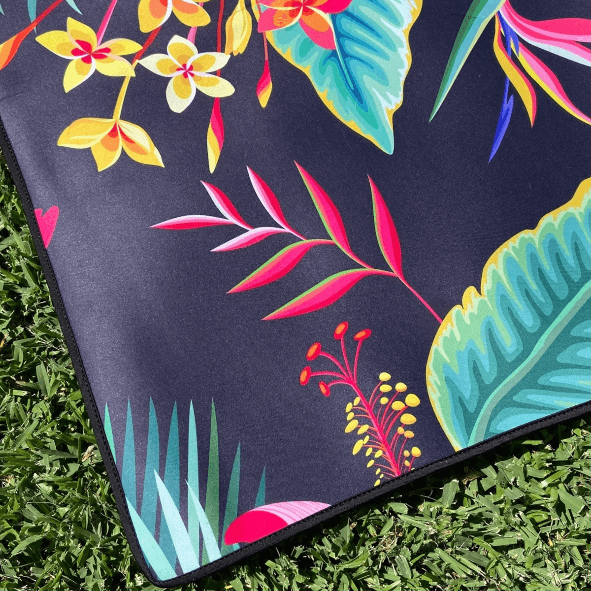 Tropical floral outdoor mat on grass, eco-friendly recycled design for picnics, camping, beach