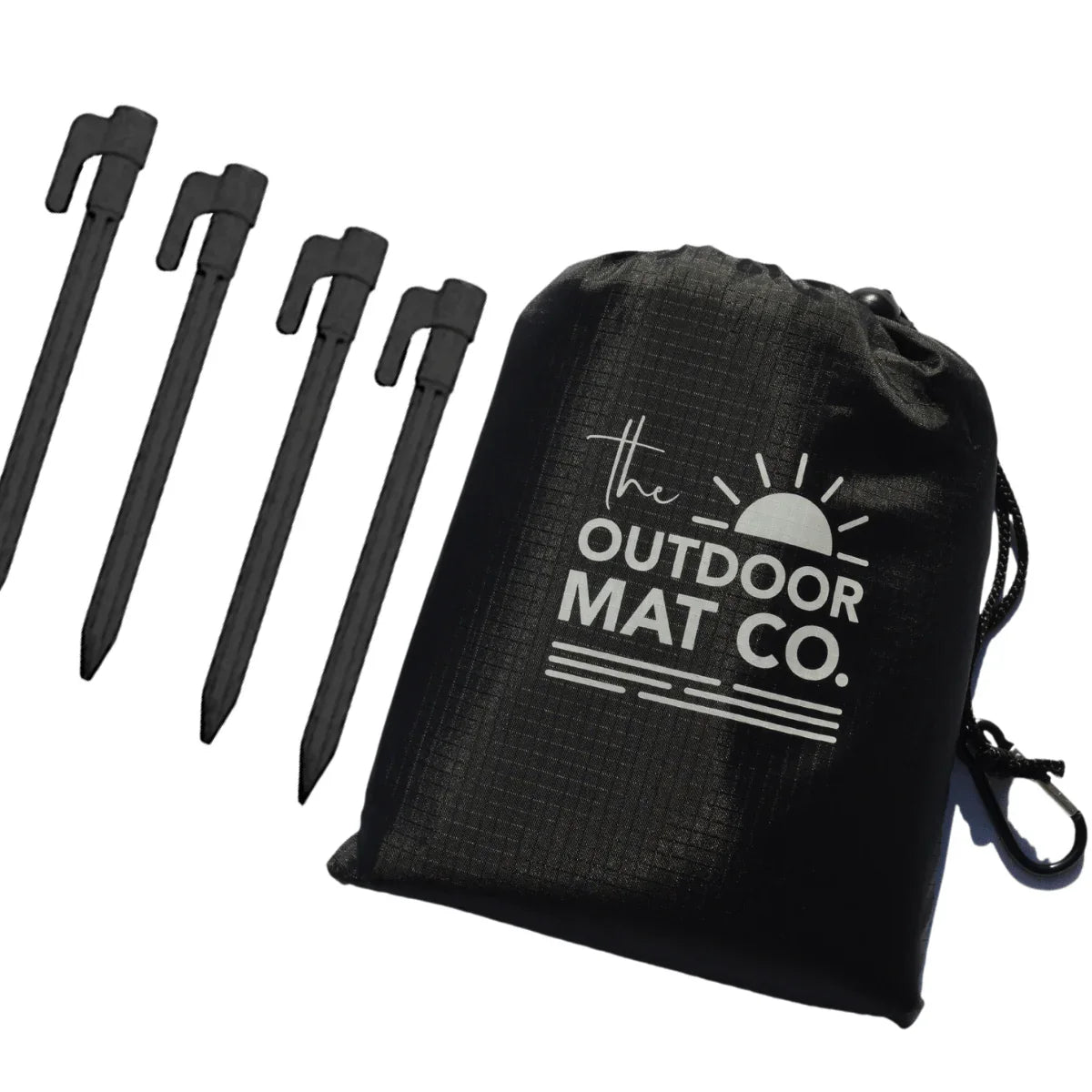 Black drawstring bag with 'The Outdoor Mat Co.' logo and four black ground stakes for securing outdoor mats
